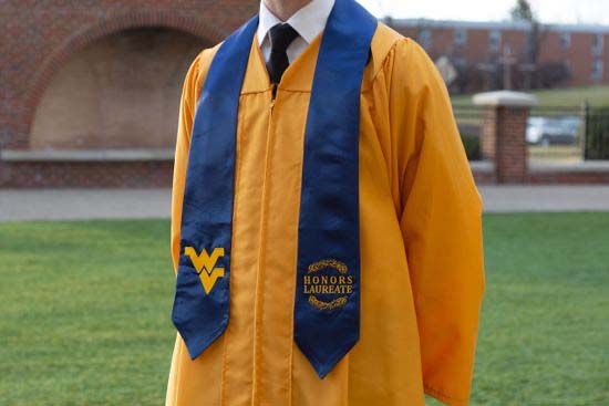 a graduate wearing a gold Honors Laureate robe and blue Honors Laureate stole