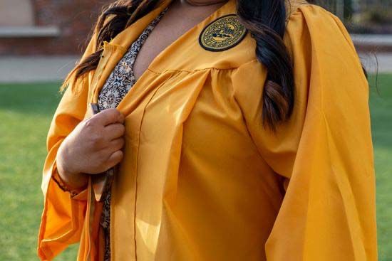 A graduate wearing a gold Honors Foundations robe